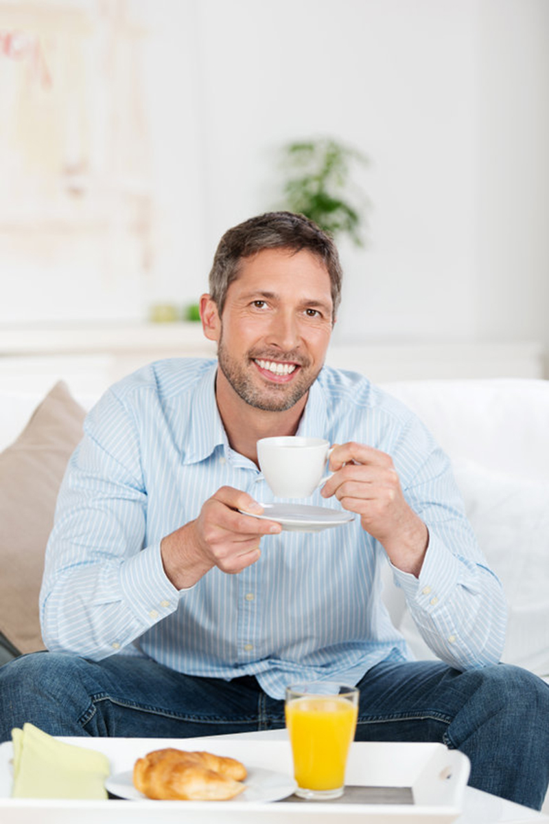 Portrait d'un homme heureux prenant son petit déjeuner