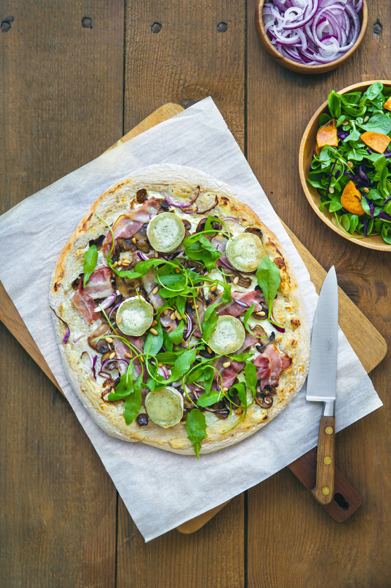 Pizza bûche de chèvre aux herbes de Provence, poitrine fumée, champignons et roquette